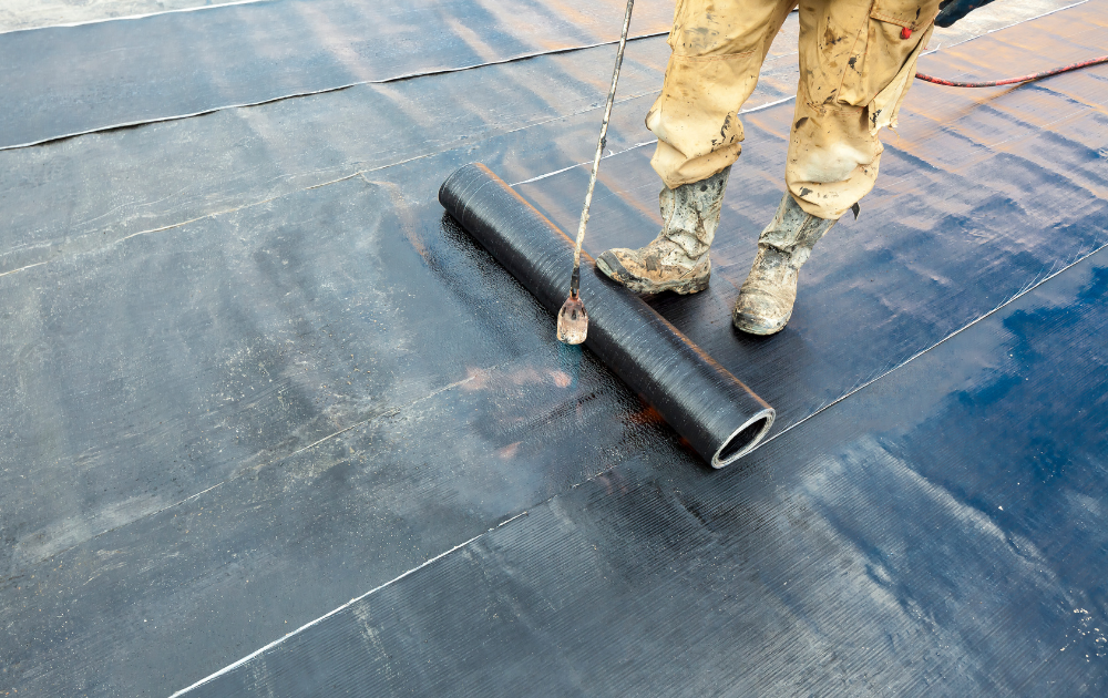 A tradesperson cleaning the water leaked surface and inspecting roof for waterproofing