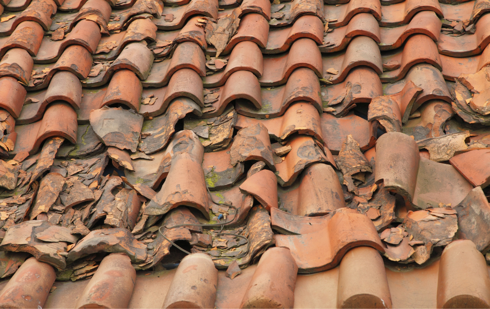 Broken tiles ripped off above the roof