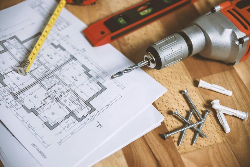 screws, a drill and plans on a table