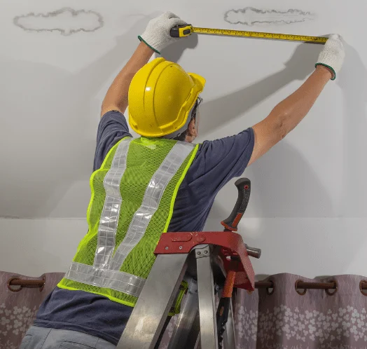 man on roof accessing roof leak