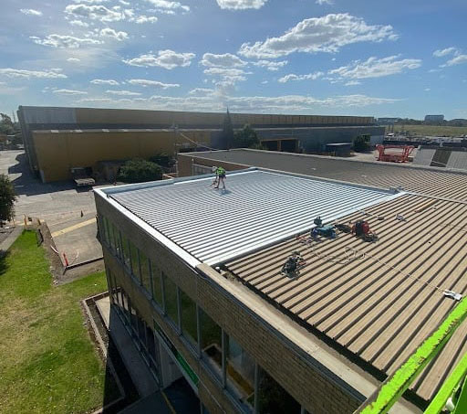 restored rusted roof after image with roofer on top