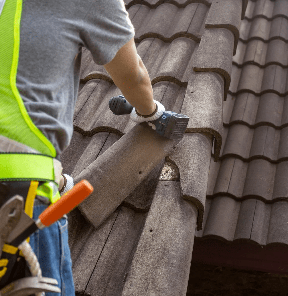 a roof repairer fixing broken roof tiles