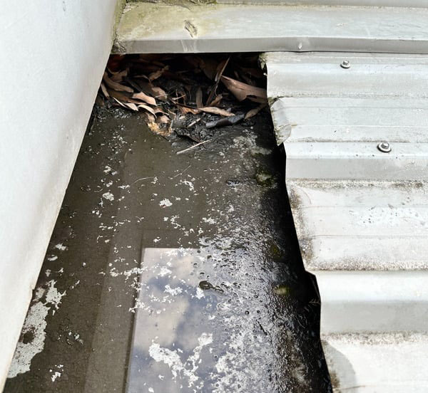 Dirty roof gutters with cartoon roofer by the right side