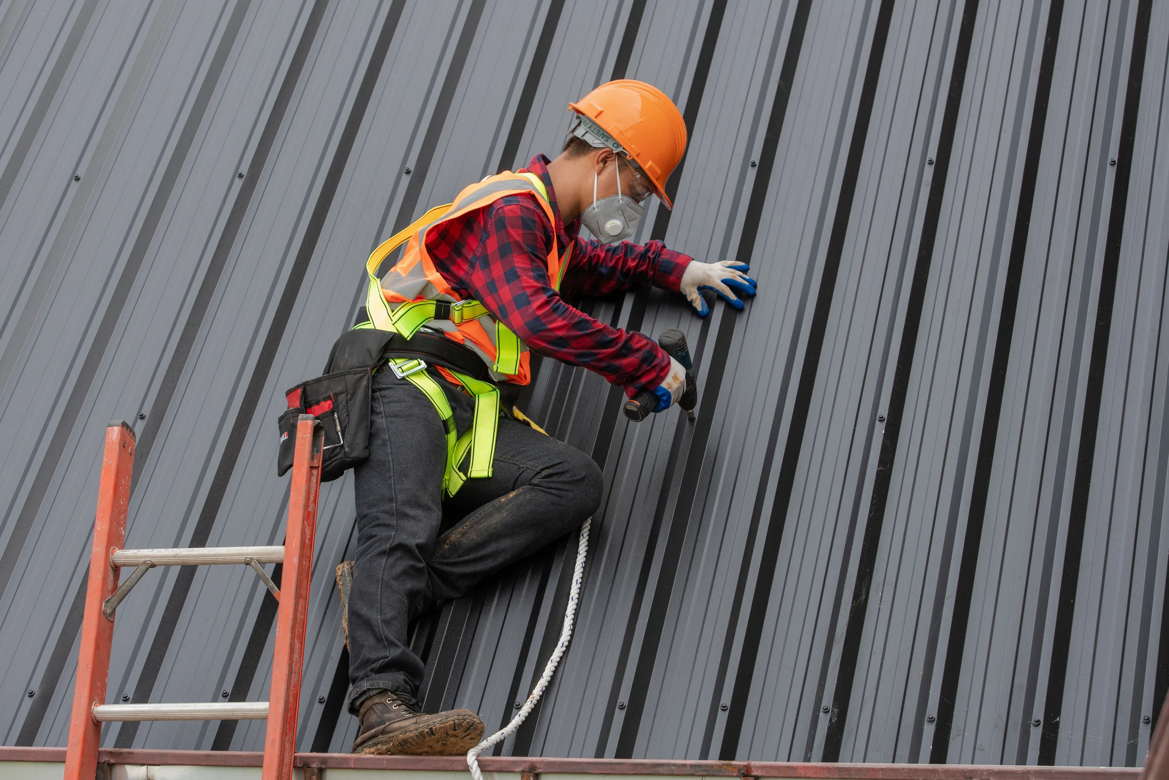 Roofer on top colorbond roof doing repairs