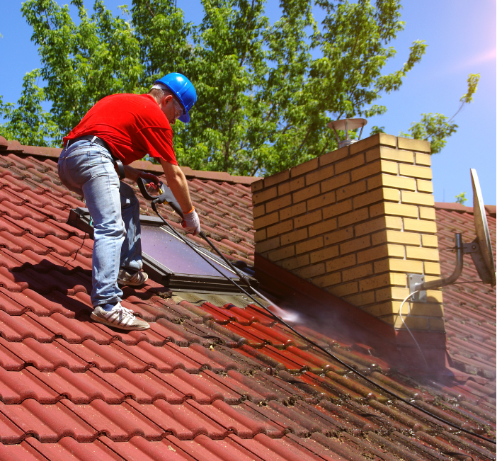 Roofer pressure washing tile roof