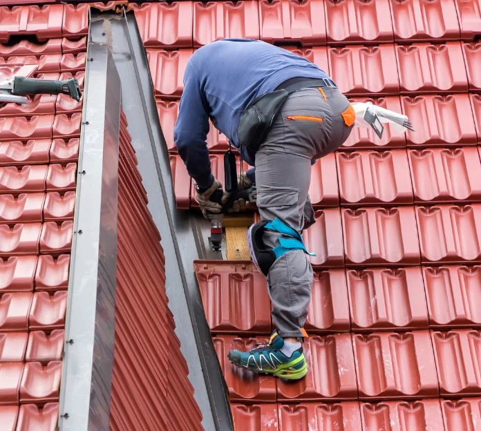 man on roof fixing roof leak in chadstone