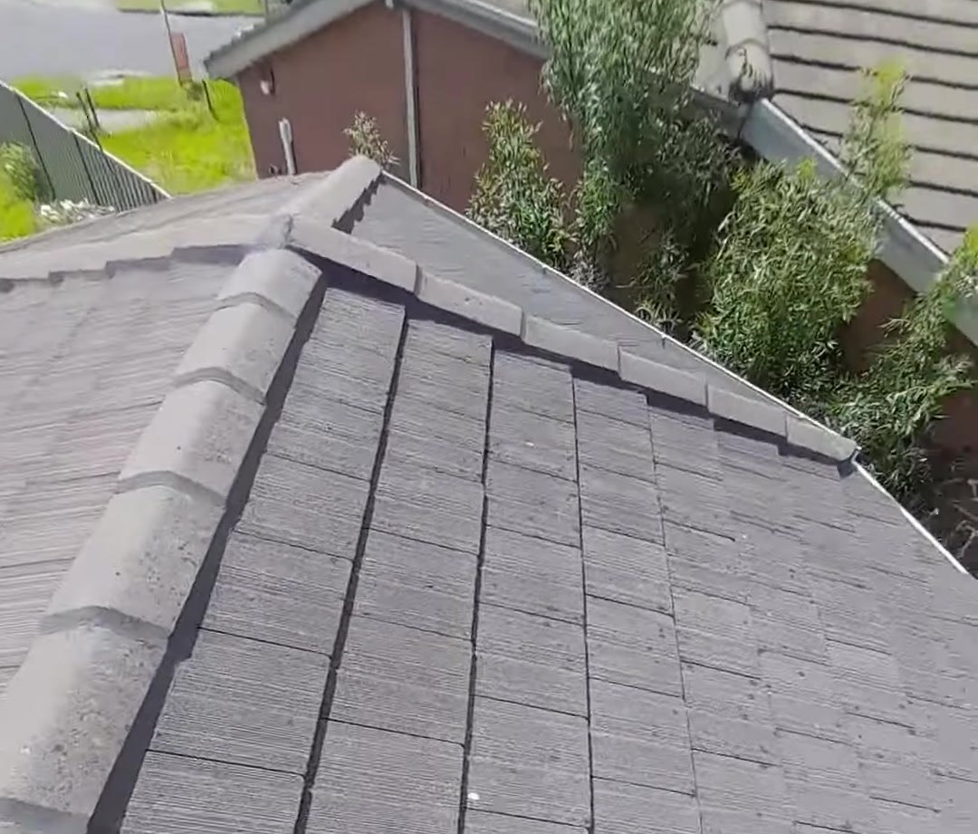 Checking concrete tile ridge capping and pointing during a roof inspection