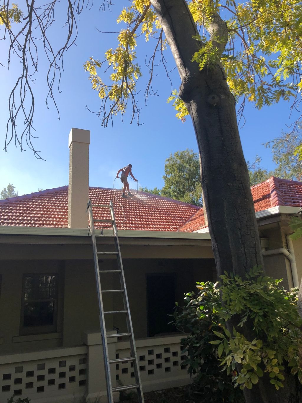 High-pressure cleaning a terracotta tile roof during a restoration on one of our jobs